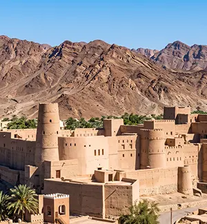 Mud-brick towers of Bahla Fort against the Jebel Akhdar foothills