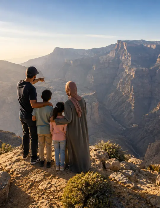 A family on the canyon rim at Omany man standing near the cliff of Jabal akhthar
