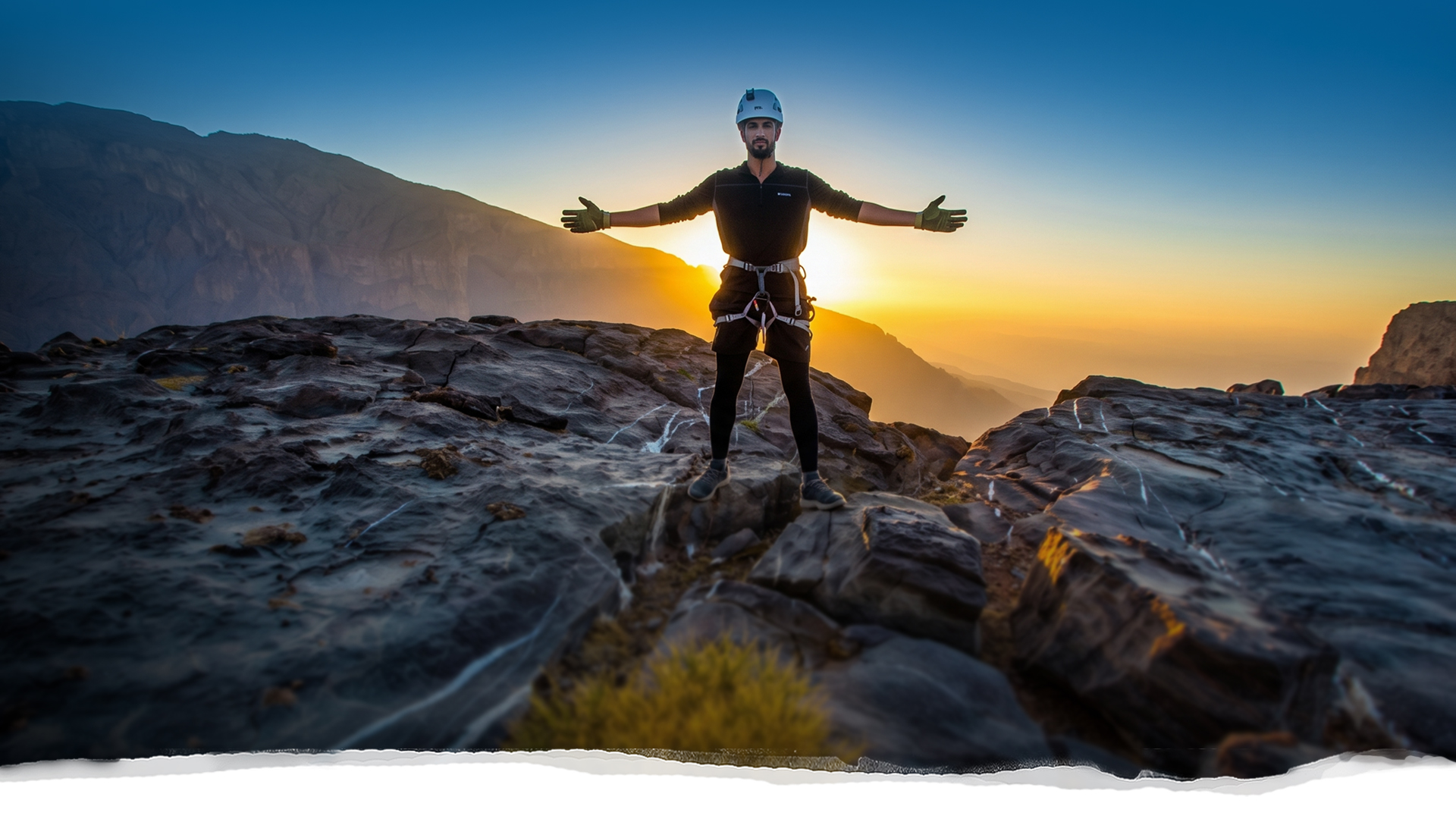 Guide standing on the cliffs of Jabal Shams at sunrise