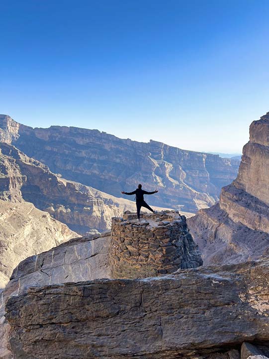 a man in the cliff of Jebel Shams