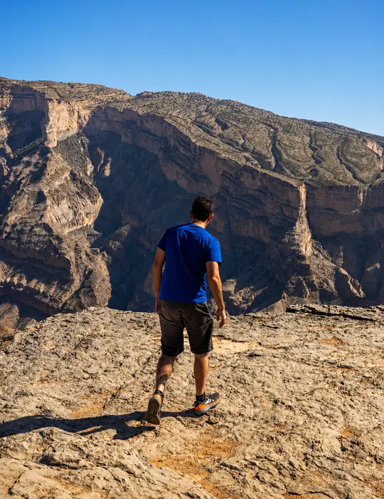 A man on the canyon rim at Jabal Shams