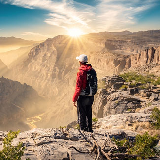 Hiker looking out over the mountains of Jabal Shams