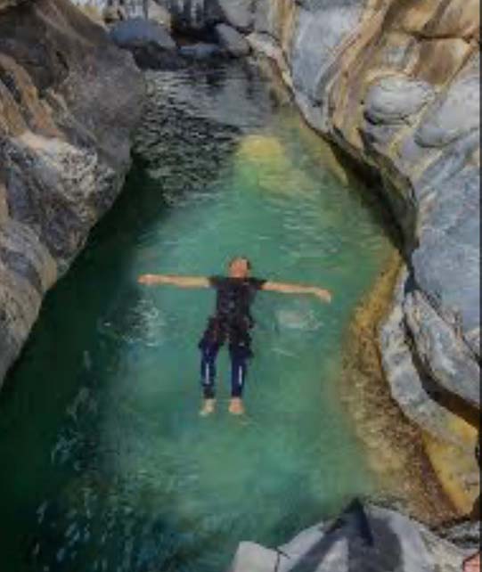 man swimming on the pool during wadi ghul adventure tour